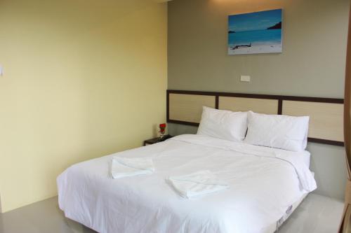 a bedroom with a large bed with white sheets at Artada Residence in Ban Laem Chabang