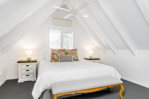 Un dormitorio blanco con una cama y dos mesitas de noche. en The Estate Byron Bay, en Bangalow