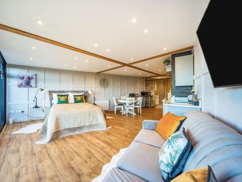 ein Schlafzimmer mit einem Bett und einem Sofa in einem Zimmer in der Unterkunft Riverview Lodge - Uk36550 in Ashleworth
