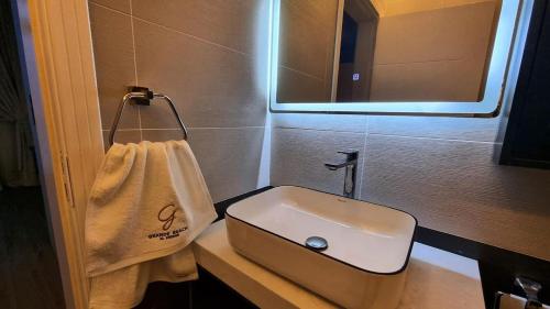 a small bathroom with a sink and a mirror at Grande Beach in An Nāmī