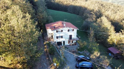 an aerial view of a house with cars parked next to it at Tolasudolsa Rooms, Breakfast & Mountain Bike in Compiano