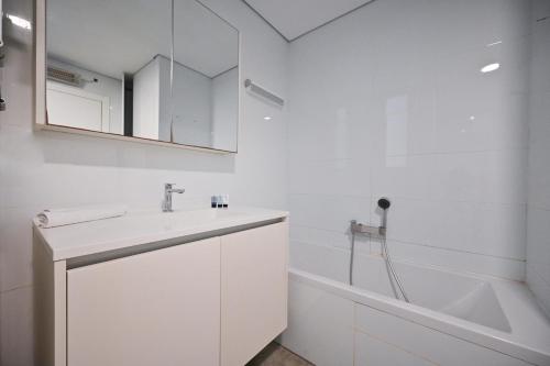 een witte badkamer met een wastafel en een bad bij Mountain Vision by HolyGuest in Tel Aviv