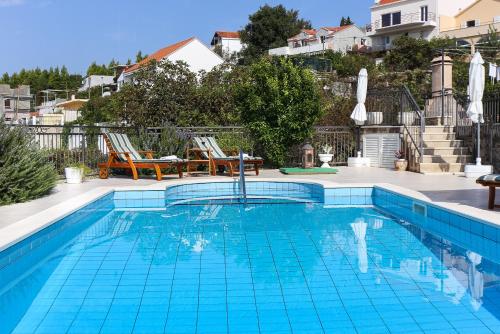 a swimming pool with blue tiles in a house at Župa Dubrovačka Guest House in Mlini