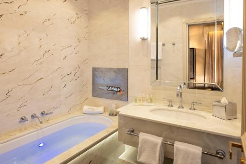 a bathroom with a tub and a sink at Manolita Paris in Paris