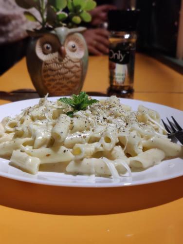 einen Teller mit Nudeln auf dem Tisch in der Unterkunft Dhauladhar Woodhouse in Malotha