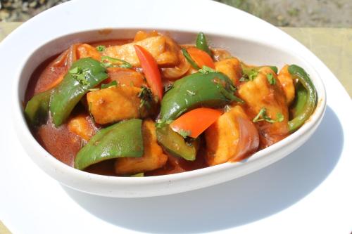 eine Schüssel mit Essen auf einem weißen Teller in der Unterkunft Dhauladhar Woodhouse in Malotha