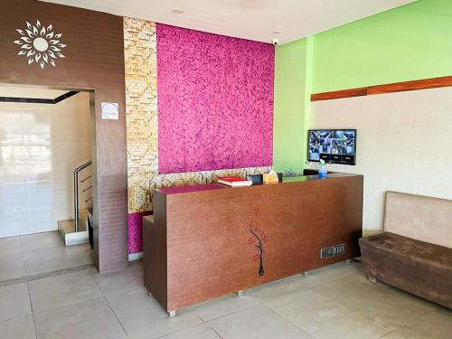 un vestíbulo con una pared rosa y un escritorio en Hotel Narmada, en Lāchharas