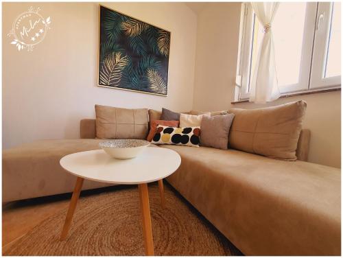 uma sala de estar com um sofá e uma mesa em Apartman Mila em Barbat na Rabu