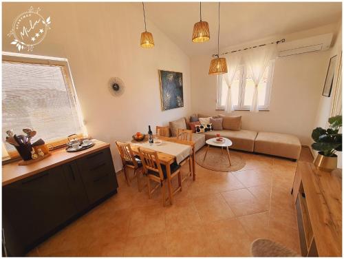 cocina y sala de estar con mesa y sofá en Apartman Mila en Barbat na Rabu
