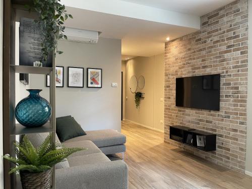 a living room with a couch and a brick wall at Casa Valla nuova e deliziosa dimora a Formigine in Formigine