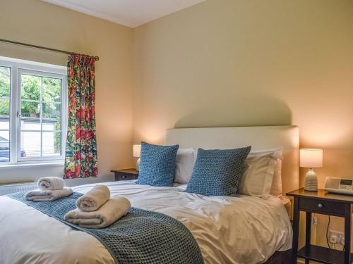 1 dormitorio con 1 cama con toallas en 8 Lowther Gardens en Grange Over Sands