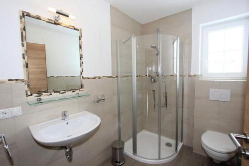 a bathroom with a shower and a sink and a toilet at Landhaus Sporer in Aschau