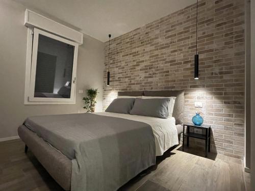 a bedroom with a large bed and a brick wall at Casa Valla nuova e deliziosa dimora a Formigine in Formigine