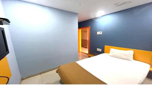 a bedroom with a bed and a blue wall at PPH Living Stepsotel in Suratakal