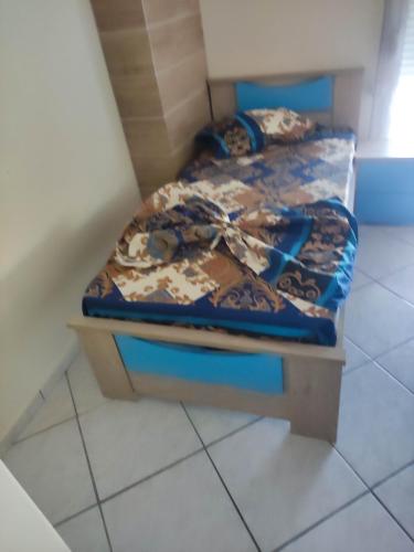 a small bedroom with a bed with a blue comforter at GCM 1 ROOMS kentro k parking in Katerini