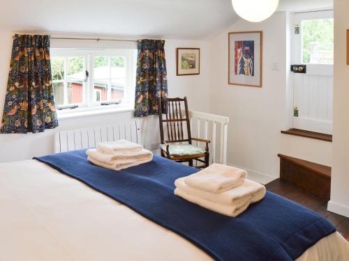 a bedroom with a bed with towels on it at Willow Cottage in Ludham