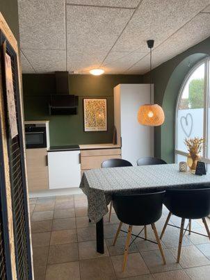 a kitchen with a table and chairs in a kitchen at GÆSTEHUSET in Tarm