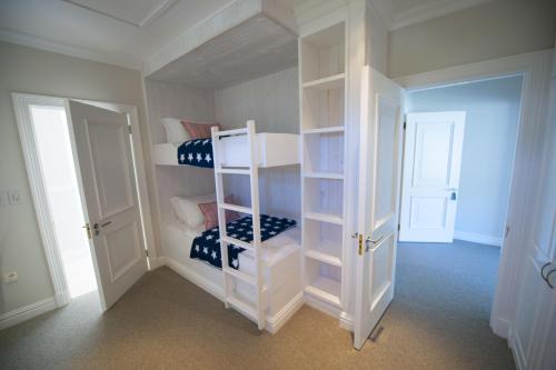 a white room with bunk beds in it at Bollard Bay House in Knysna