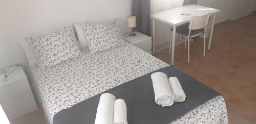 Un dormitorio con una cama con toallas blancas. en C&BLOLA - Habitacion independiente con baño privado y aire acondicionado - Minimo 3 dias en Puerto Real