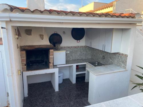 an outdoor kitchen with a table and a stove at Casa Riumar Ebre in Riumar