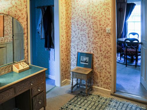 Cette chambre dispose d'un miroir et d'une table avec une photo. dans l'établissement Peggs Yard, à Aylsham