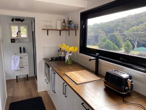 a kitchen with a counter with a large window at Adina Tiny House Bruny Island in South Bruny