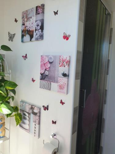 a bathroom with butterflies on the wall at gîte m et m in Nébouzat