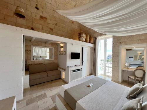 a bedroom with a large bed and a living room at Vittorio Emanuele Charming Suites in Monopoli