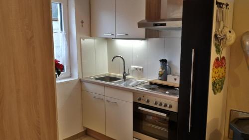 a small kitchen with a sink and a stove at Ferienwohnung Heissl in Fieberbrunn