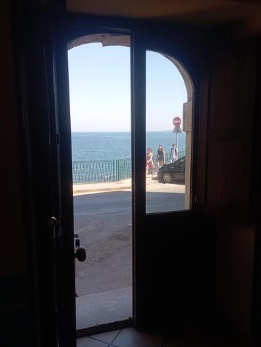an open door with a view of the ocean at Life Hotels Residence dei Baroni in Siracusa