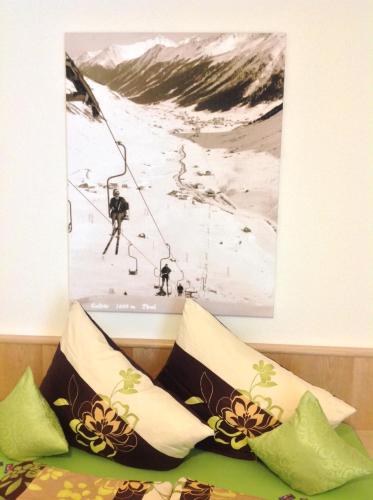 a painting hangs above a bed with pillows at fabienne - Silvretta Premium Card Betrieb in Galtür