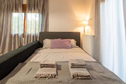 a bedroom with a bed with two towels on it at Alice House 2 in Amarynthos