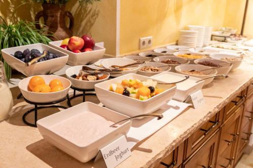 a buffet with bowls of fruit and other food on a table at Hotel Pension Sonnleiten in Tux
