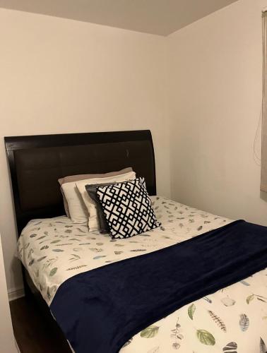 a bed with a black headboard and two pillows on it at Juana's private room in Manchester