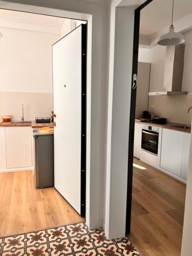 an open door to a kitchen with white cabinets at ADI BOUTIQUE HOUSE in Thessaloniki