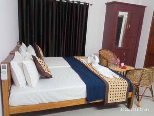 Devi Kripa Residency في فاركَالا: غرفة نوم بسرير وطاولة وكراسي