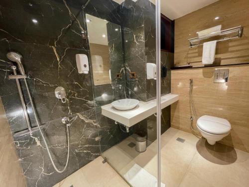 uma casa de banho com um chuveiro, um WC e um lavatório. em Comfort Hotel Vista em Lucknow