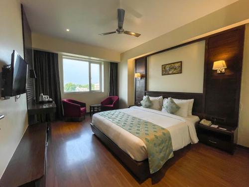 une chambre d'hôtel avec un lit et une télévision dans l'établissement Comfort Hotel Vista, à Lucknow