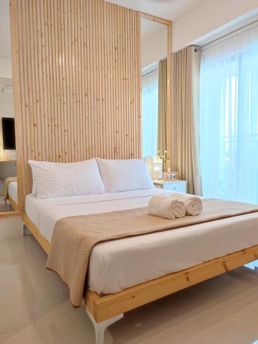a bedroom with a large bed with a large window at Inspiria Davao in Davao City
