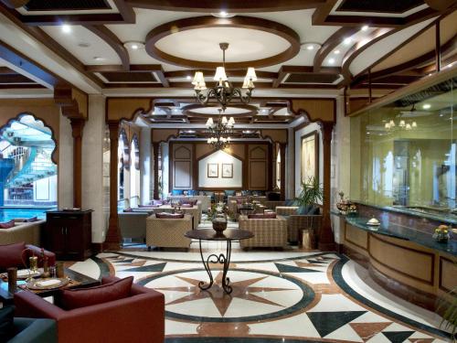 a lobby with a restaurant with tables and chairs at Avari Lahore Hotel in Lahore