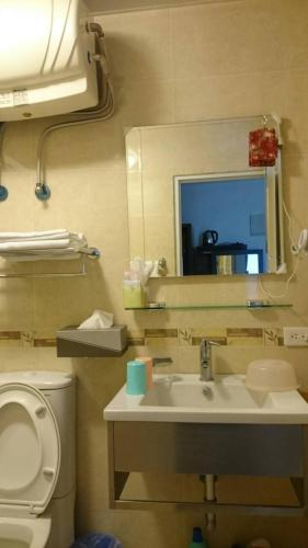 a bathroom with a sink and a toilet and a mirror at Ziteng Hua Homestay in Hualien City