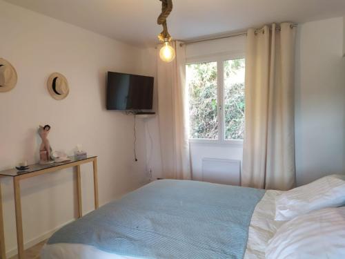 a bedroom with a bed and a window at Ma villa au bord de l'eau in Miremont