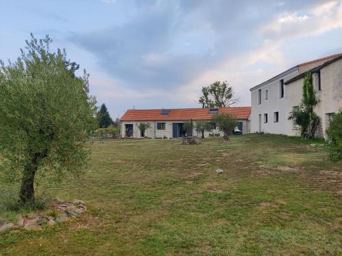 an empty field next to a white building at Ravissante Suite 90m2 près des bord de Loire in Saint-Julien-de-Concelles