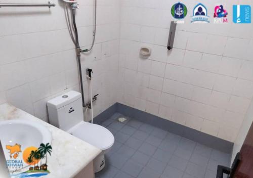 a bathroom with a white toilet and a sink at GLOBAL IKHWAN RESORT in Kuah