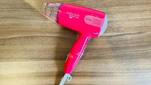 a pink hair dryer sitting on a wooden table at Hostel Inn Hashimoto in Hashimoto