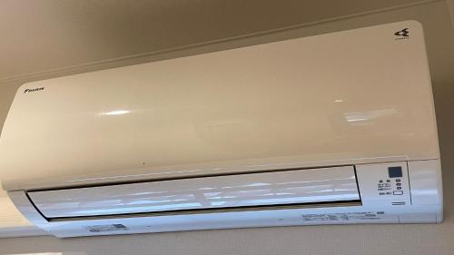 a white microwave oven sitting on top of a wall at Hostel Inn Hashimoto in Hashimoto