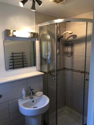 een badkamer met een wastafel en een douche bij Locka Old Hall Cottage in Arkholme