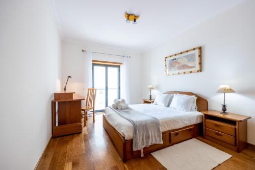 a bedroom with a bed and a desk and a window at IM On Ameijeira in Lagos