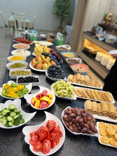al Madina Hotel Samarkand في سمرقند: طاولة طويلة مليئة بصحون مختلف أنواع الطعام