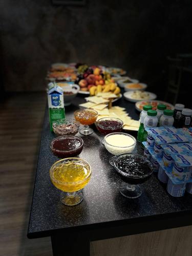 al Madina Hotel Samarkand في سمرقند: طاولة عليها العديد من أطباق الطعام والمشروبات المختلفة